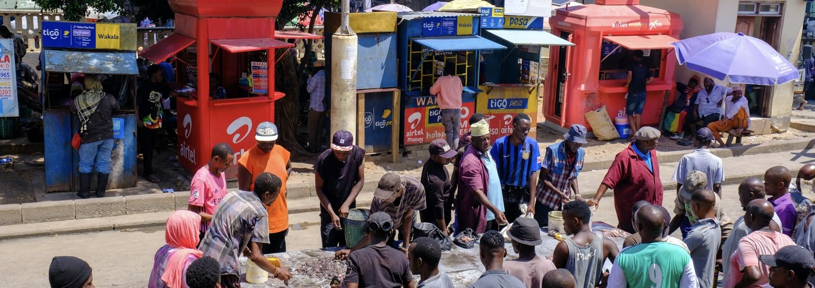 A busy local market with mobile-money kiosks